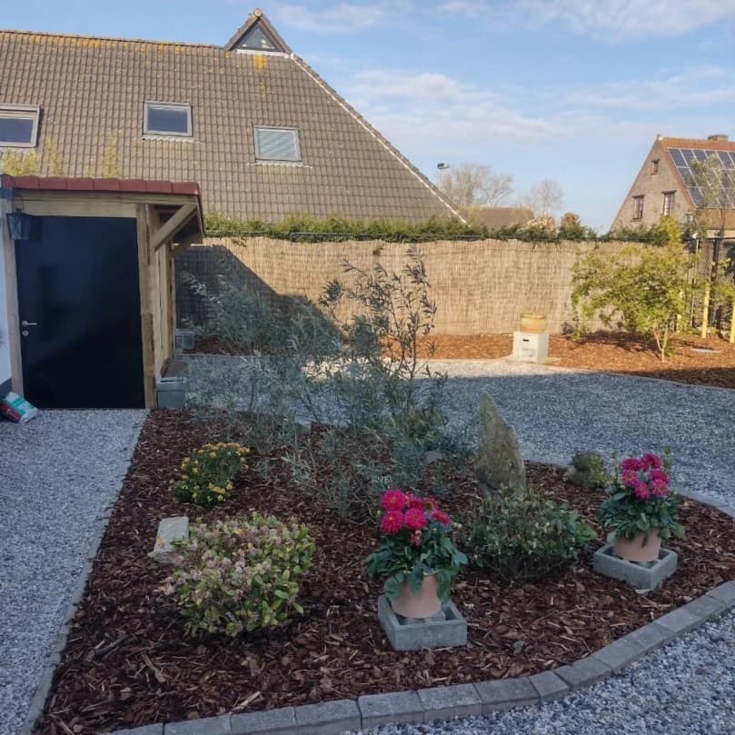 Aangelegde tuin met grind, borders en bloeiende planten